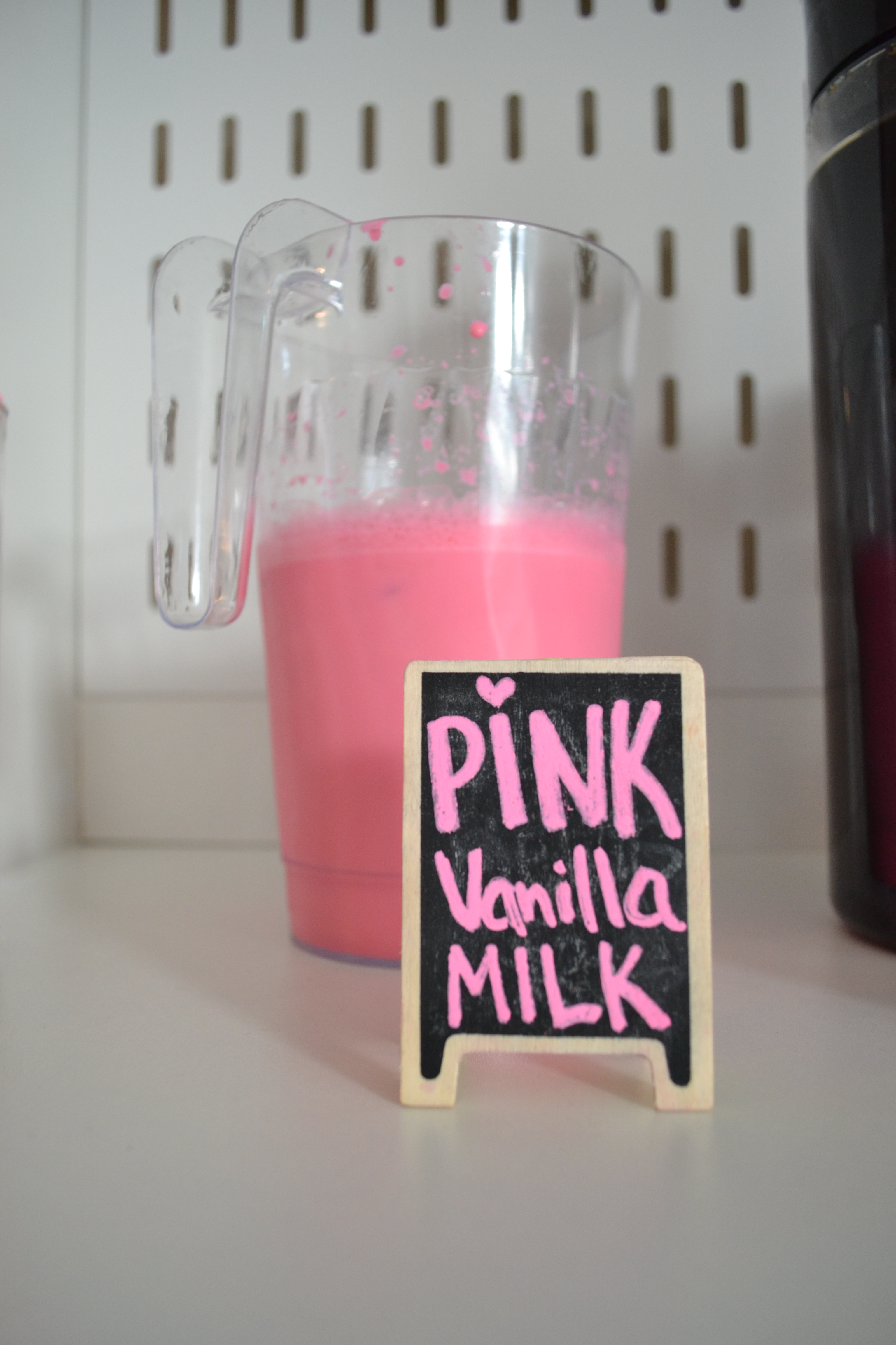 pink vanilla milk sign and jug on a bar