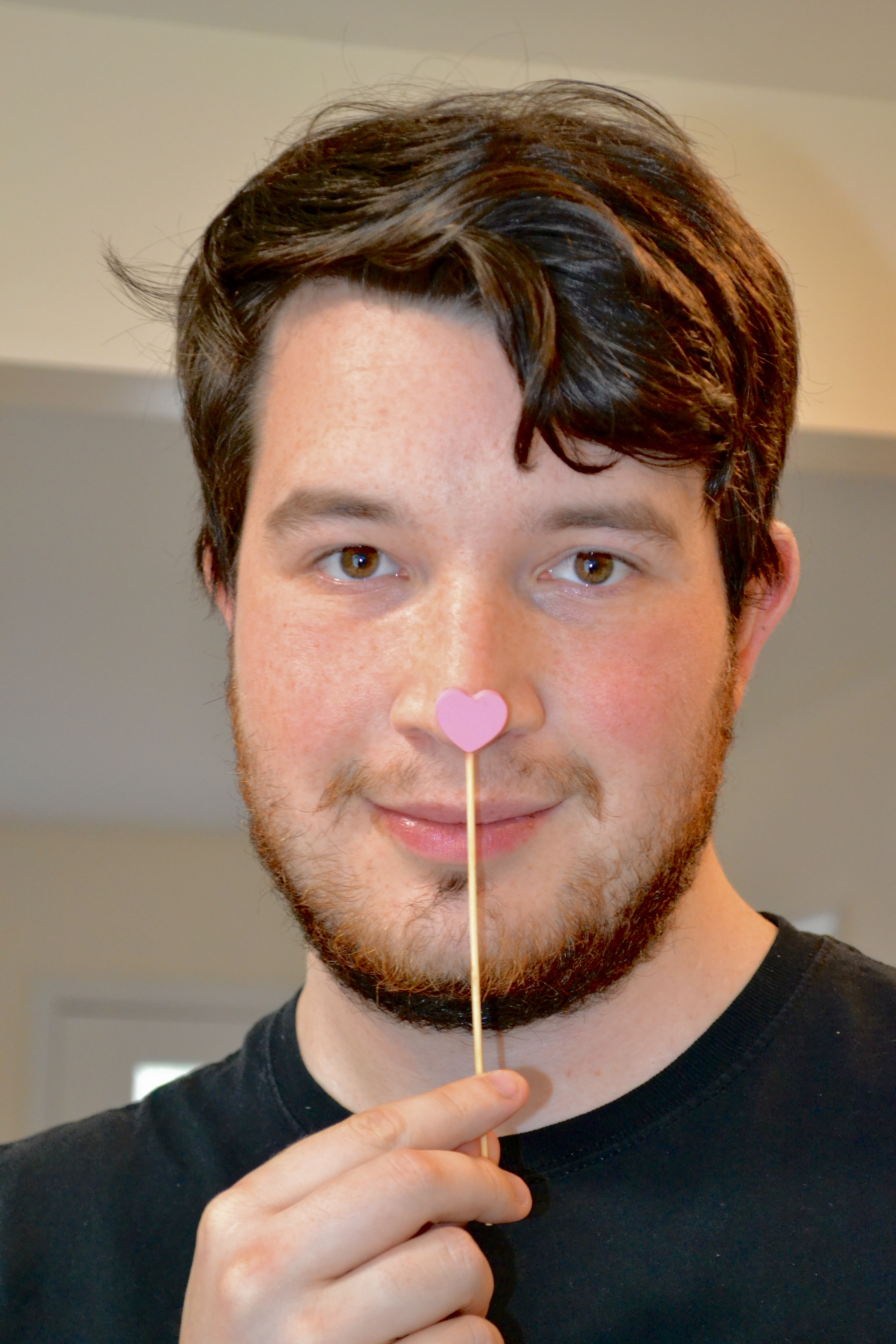 Photo of Russell Fleming placing a heart stick to his nose.